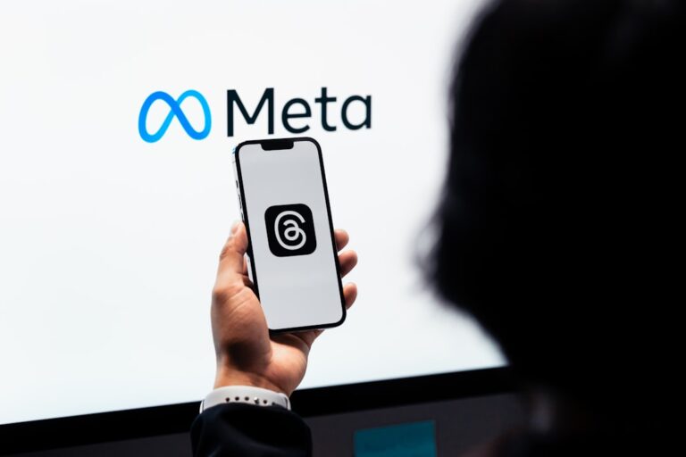 Uma Pessoa Segurando Um Celular Na Frente De Uma Tela Grande KUATfFyJQQ4