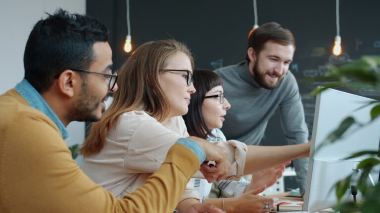 Equipe Diversificada Colaborando Em Torno De Uma Tela De Computador Y32qbykD69g