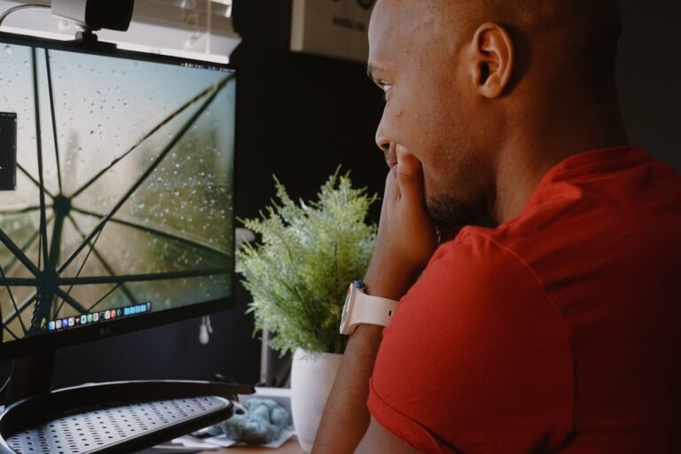 Um Homem Sentado Na Frente De Um Monitor De Computador MJUvXbVZwjs