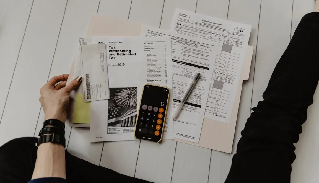 Person Holding Paper Near Pen And Calculator XoU52jUVUXA