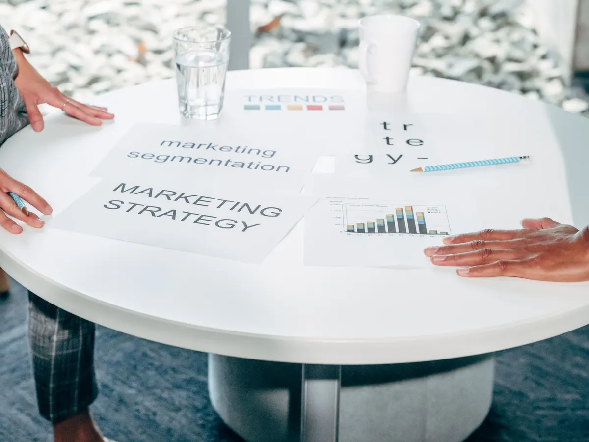 Two professionals collaborate on marketing strategy and segmentation at a round table.