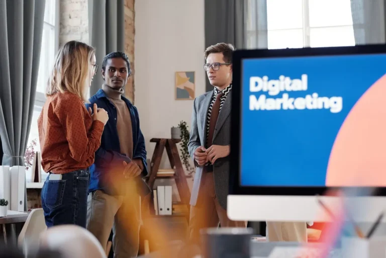 Group of colleagues discussing digital marketing strategies in an office setting.